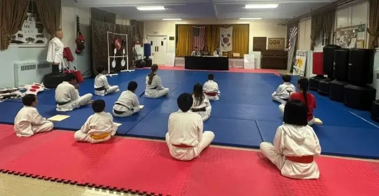 Students sitting on mat in a martial arts class